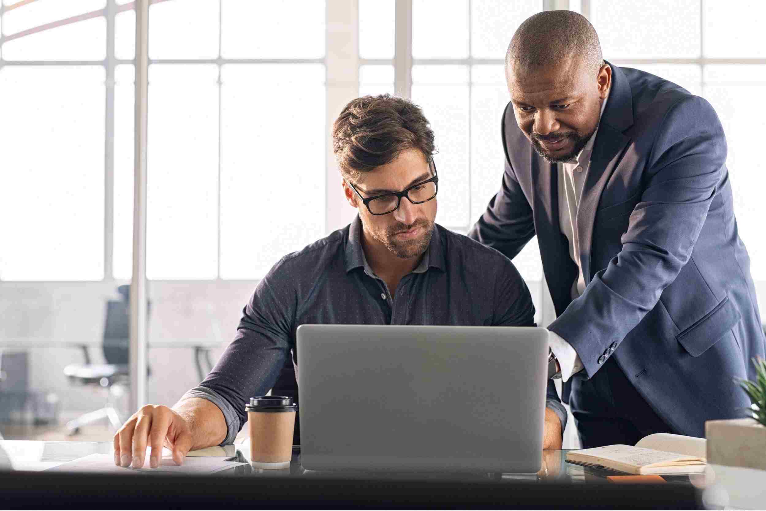 Two Men looking at improving workforce management on a laptop