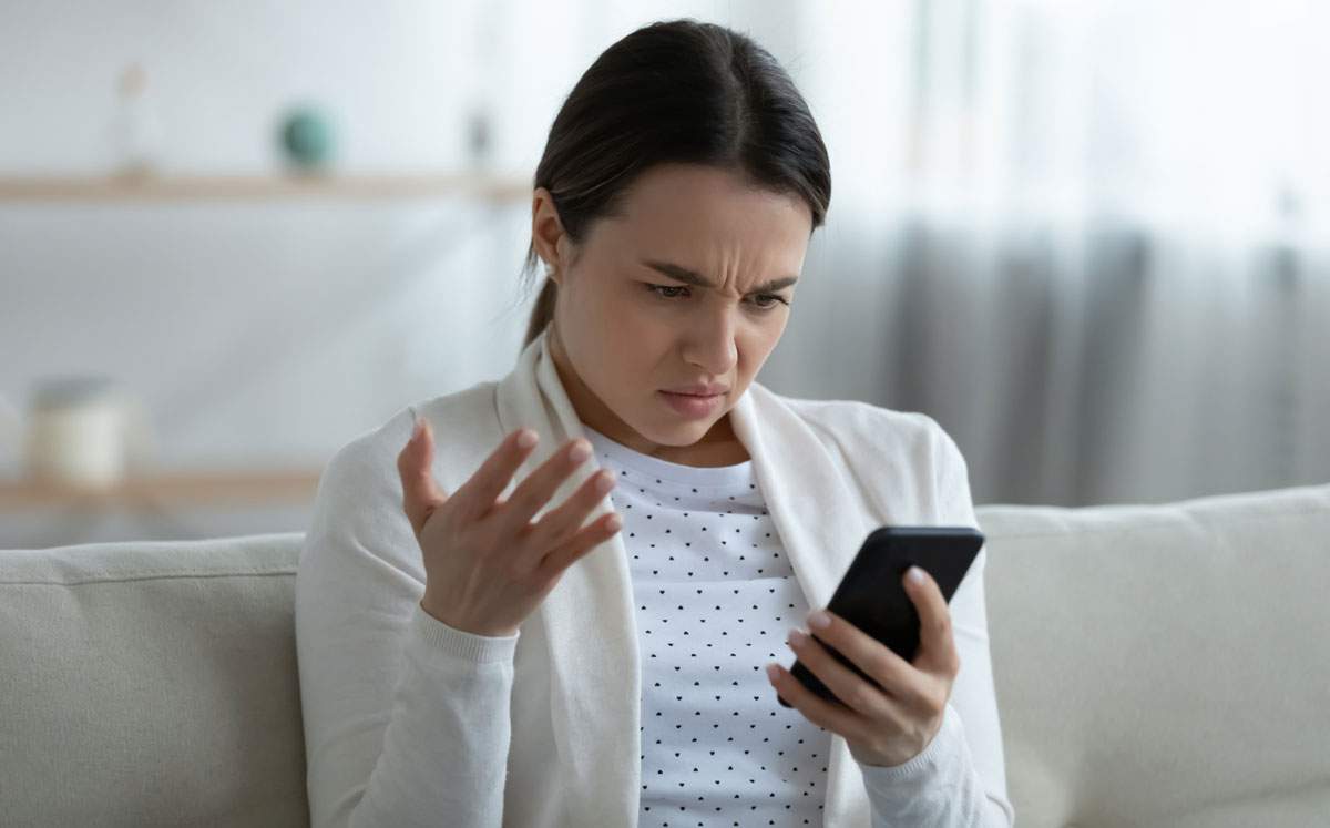 Woman Looking at Smartphone wondering why Facebook is not working